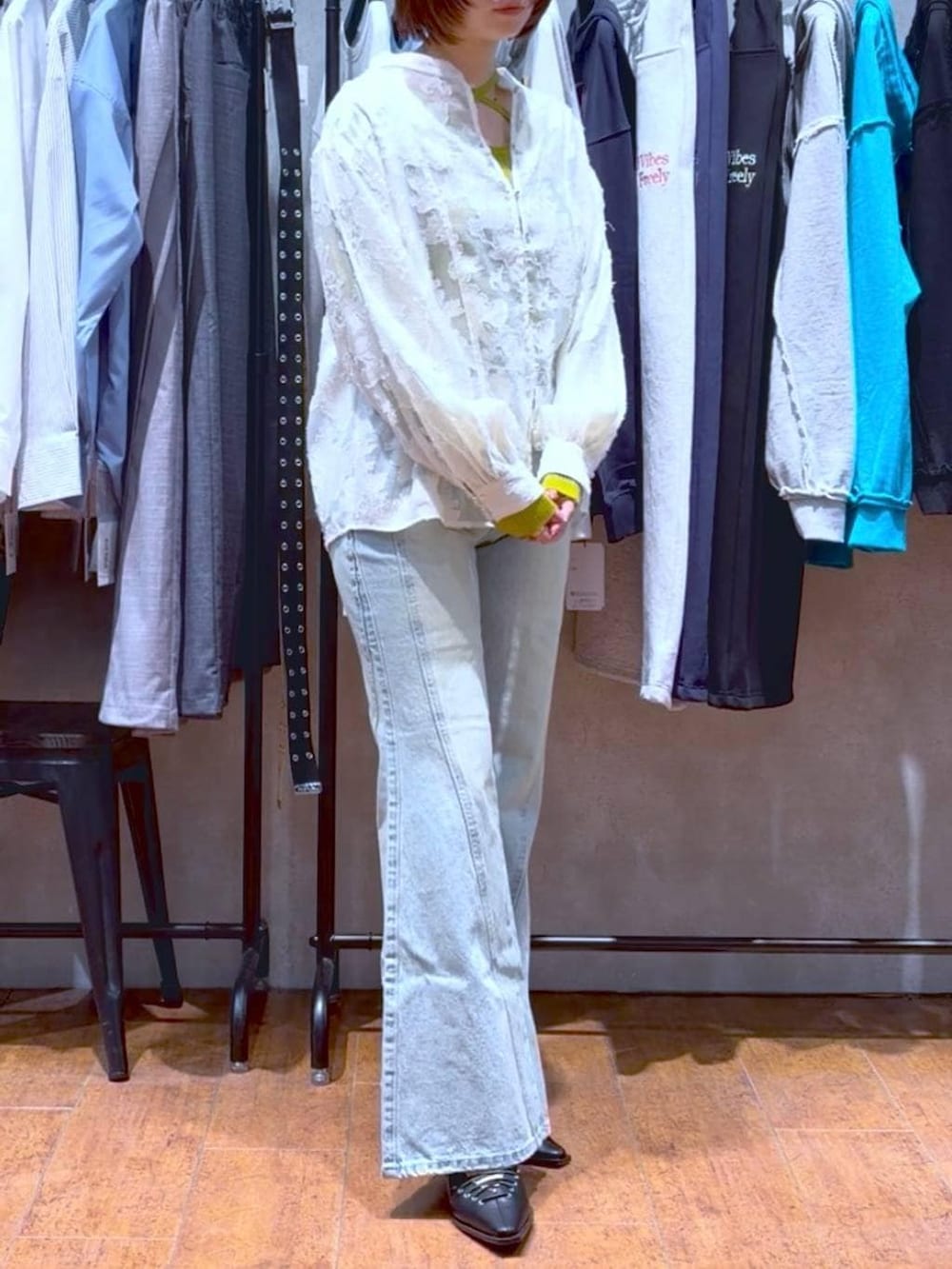 ブルー系のデニムパンツ、ホワイト系のボストンバッグ、イエロー系のニット/セーターを着用したレディースの春コーディネートの6枚目の写真