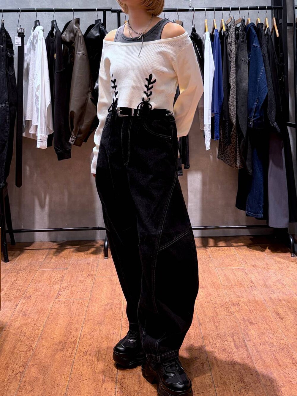 ブラック系のデニムパンツ、ブラック系のスニーカー、ホワイト系のニット/セーターを着用したレディースの秋コーディネートの6枚目の写真