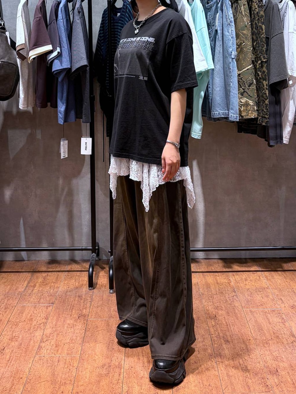 ブラウン系のデニムパンツ、ブラック系のTシャツ/カットソー、ブラック系のブーツを着用したレディースの夏コーディネートの3枚目の写真