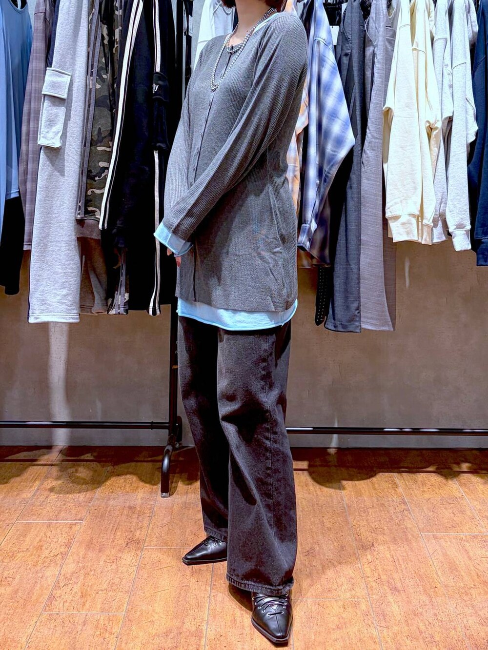 ブラック系のスラックス、ブラック系のサンダル、グレー系のチュニックを着用したレディースの春コーディネートの2枚目の写真