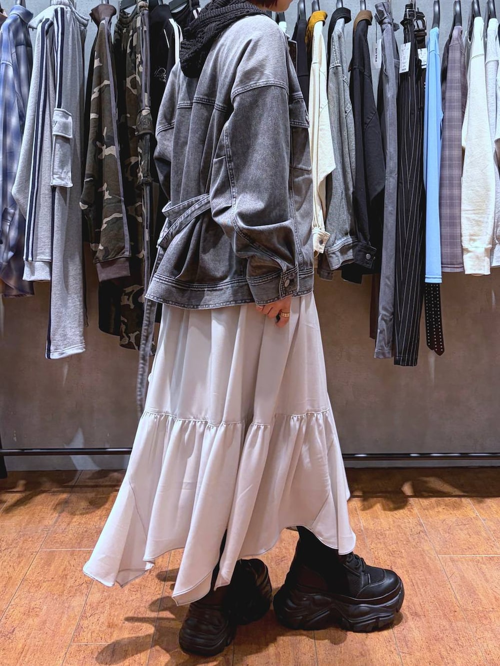 ブラック系のブーツ、ホワイト系のキャミソール、ベージュ系のスカートを着用したレディースの春コーディネートの7枚目の写真