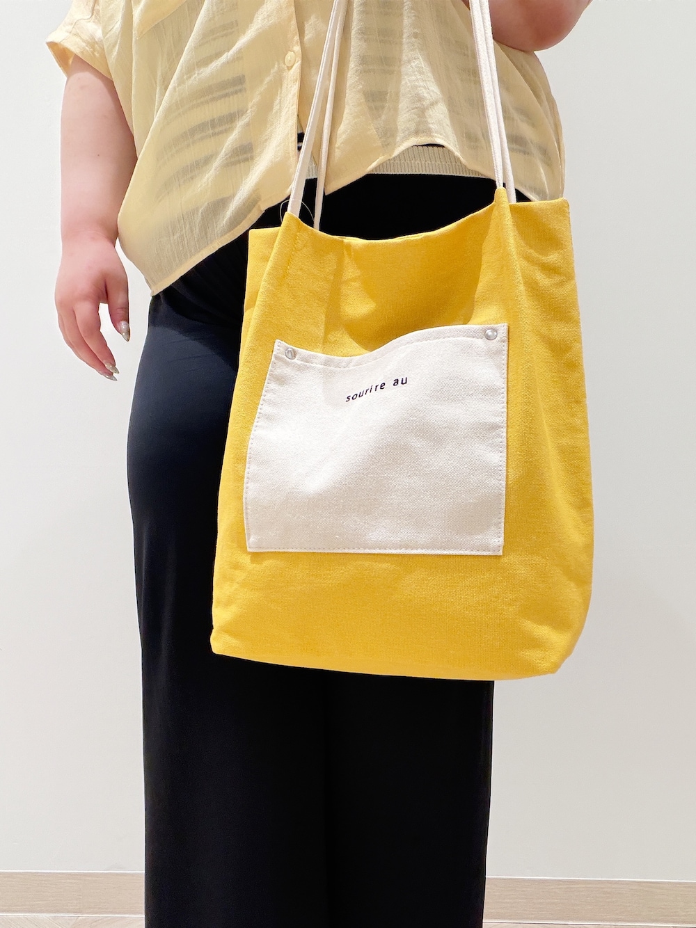 イエロー系のシャツ/ブラウス、ベージュ系のニット/セーター、ブラック系のその他パンツを着用したレディースの夏コーディネートの4枚目の写真