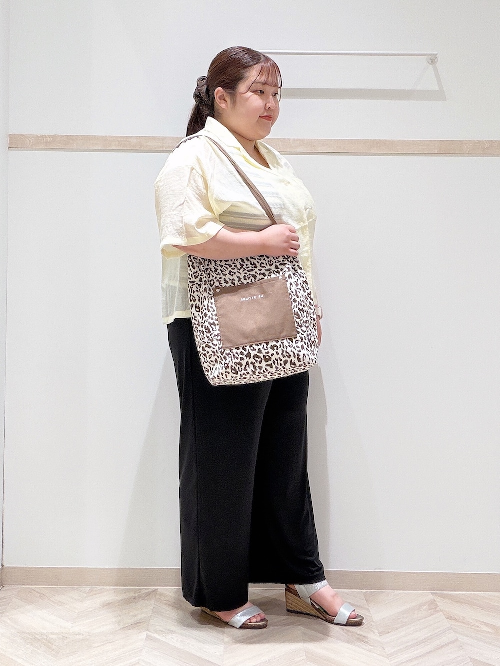イエロー系のシャツ/ブラウス、ベージュ系のニット/セーター、ブラック系のその他パンツを着用したレディースの夏コーディネートの2枚目の写真