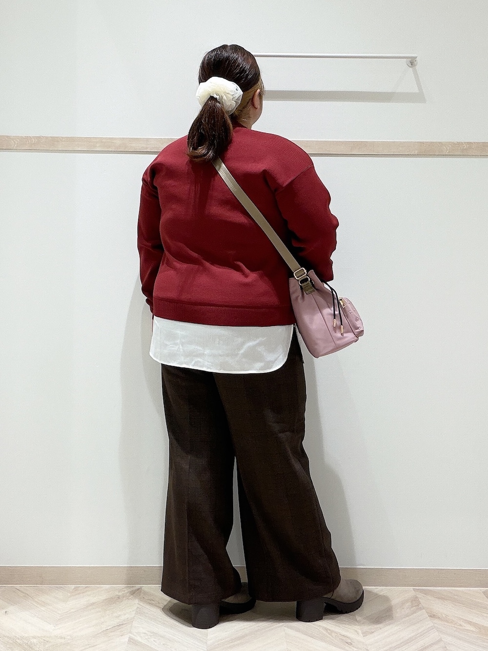 レッド系のニット/セーター、ブラウン系のその他パンツ、ブラウン系のブーツを着用したレディースの秋コーディネートの4枚目の写真