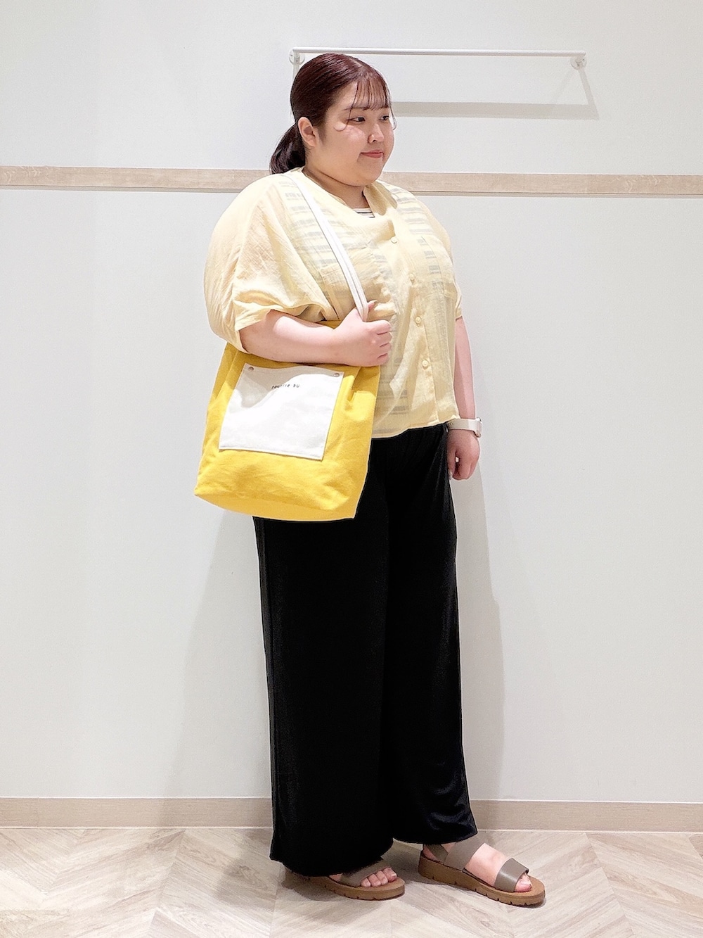 イエロー系のシャツ/ブラウス、ベージュ系のニット/セーター、ブラック系のその他パンツを着用したレディースの夏コーディネートの2枚目の写真