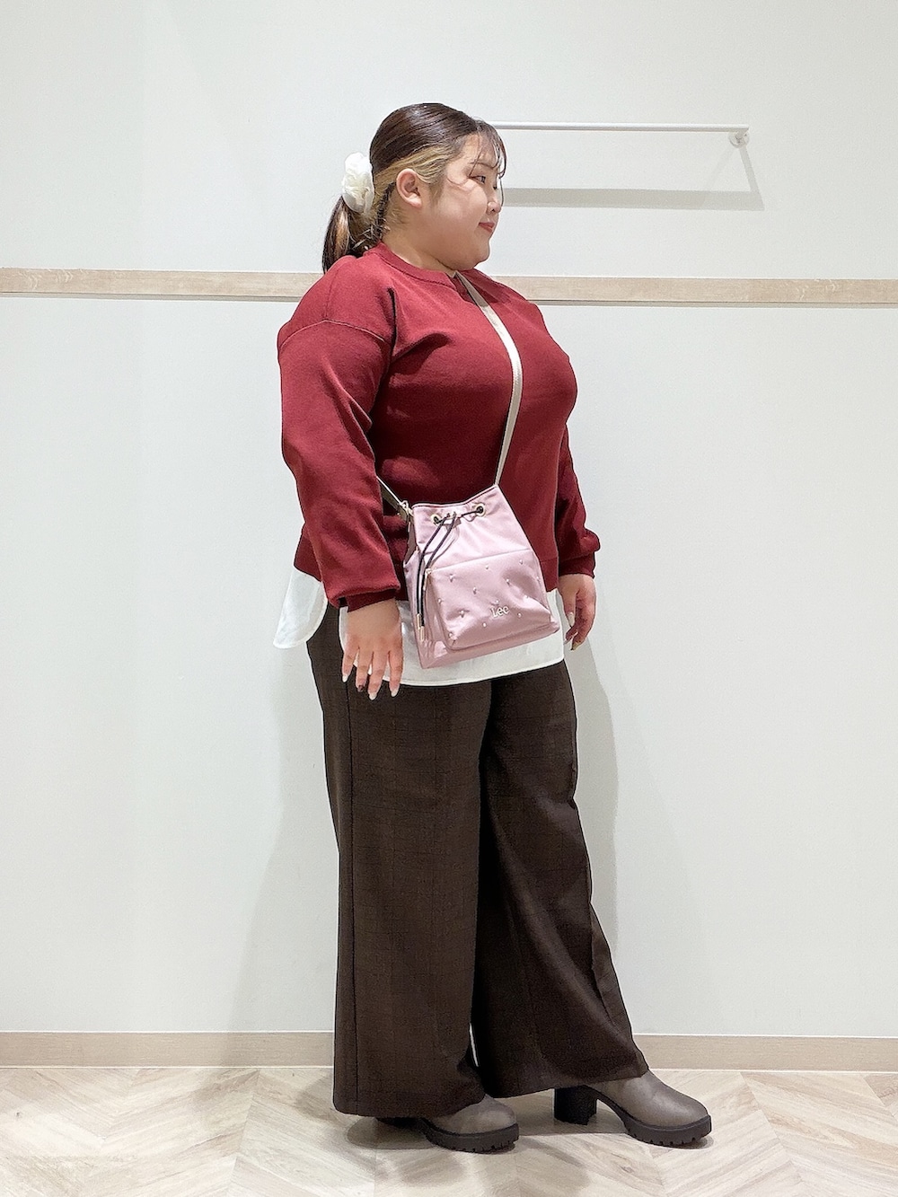 レッド系のニット/セーター、ブラウン系のその他パンツ、ブラウン系のブーツを着用したレディースの秋コーディネートの3枚目の写真