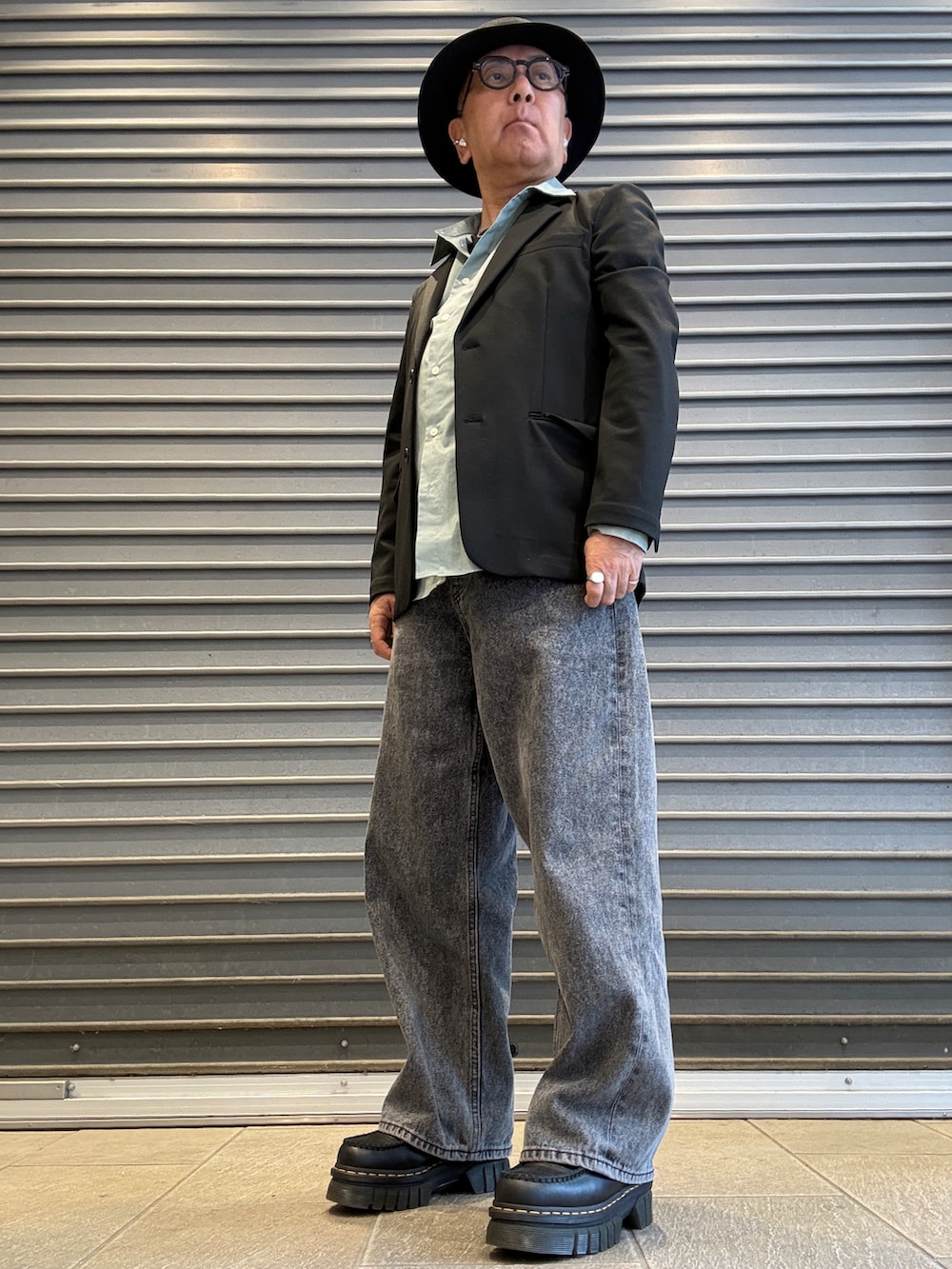 ブラック系のテーラードジャケット、ブラック系のローファー、グリーン系のシャツ/ブラウスを着用したメンズの春コーディネートの2枚目の写真