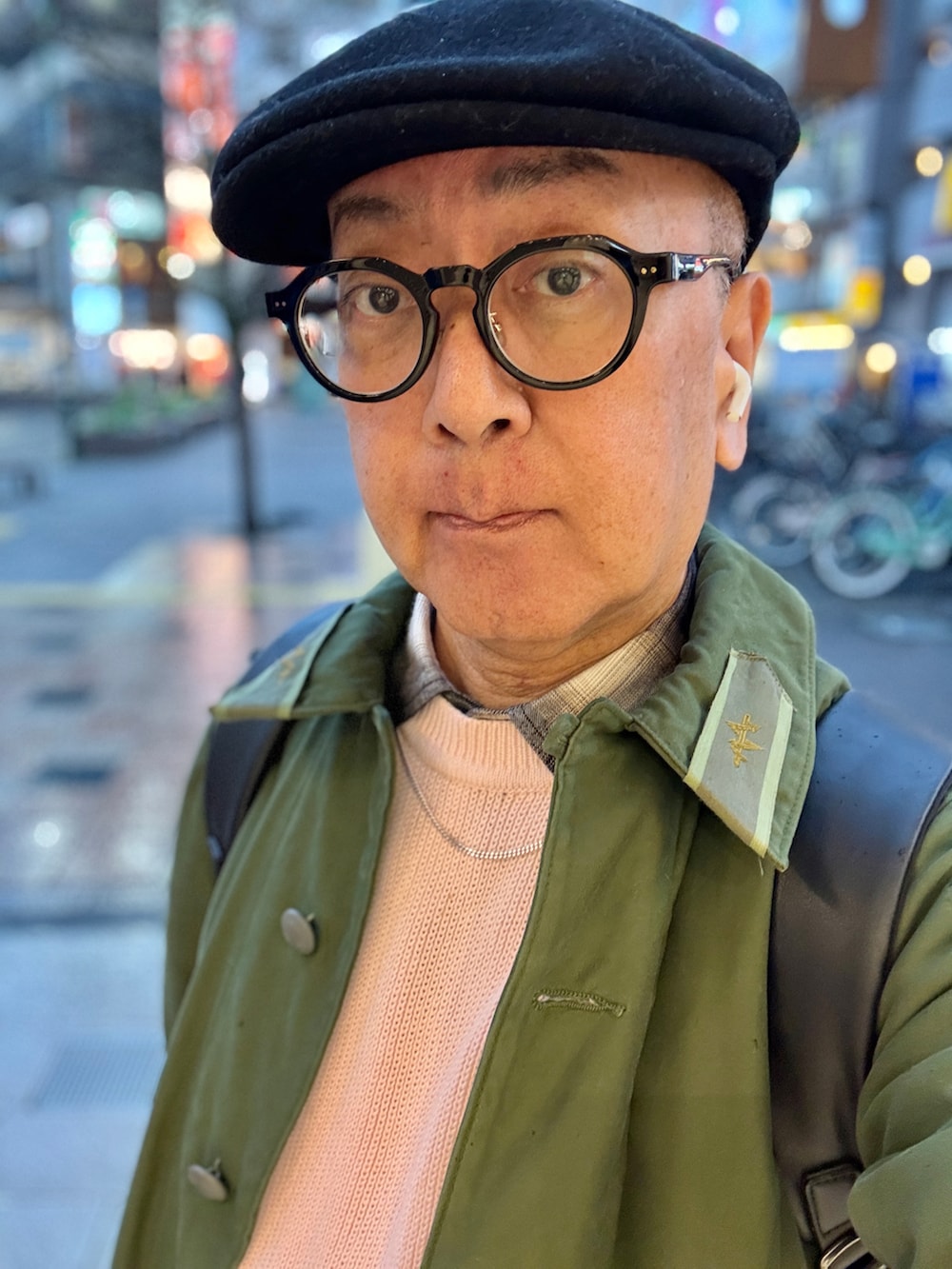 ブラック系のスニーカー、ピンク系のニット/セーター、ブラック系のシャツ/ブラウスを着用したメンズの春コーディネートの3枚目の写真