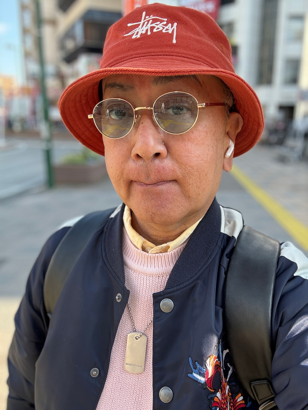 イエロー系のシャツ/ブラウス、ピンク系のニット/セーター、ブルー系のスカジャンを着用したメンズの春コーディネートの3枚目の写真