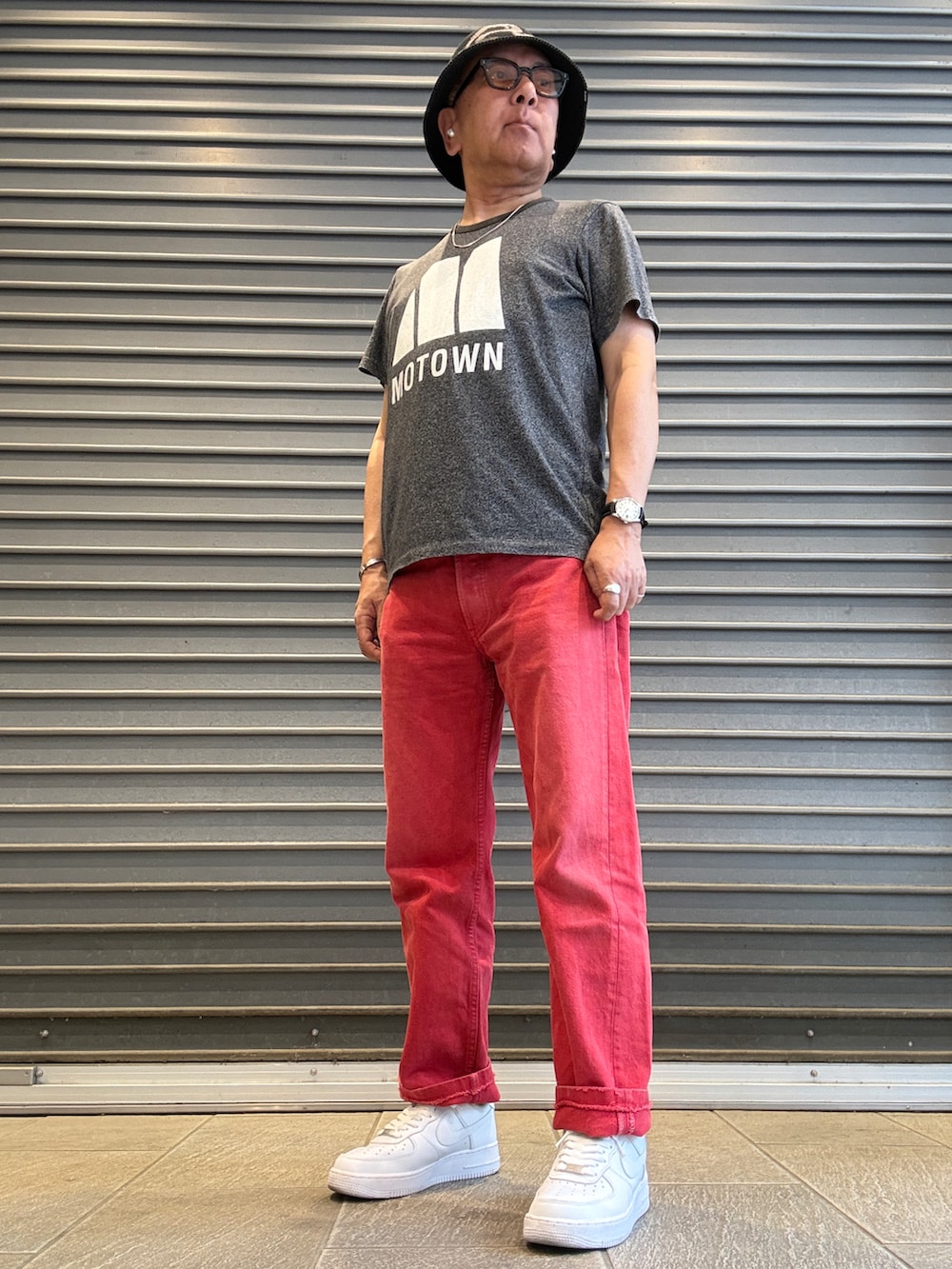 ホワイト系のスニーカー、グレー系のTシャツ/カットソー、レッド系のデニムパンツを着用したメンズの春コーディネートの2枚目の写真