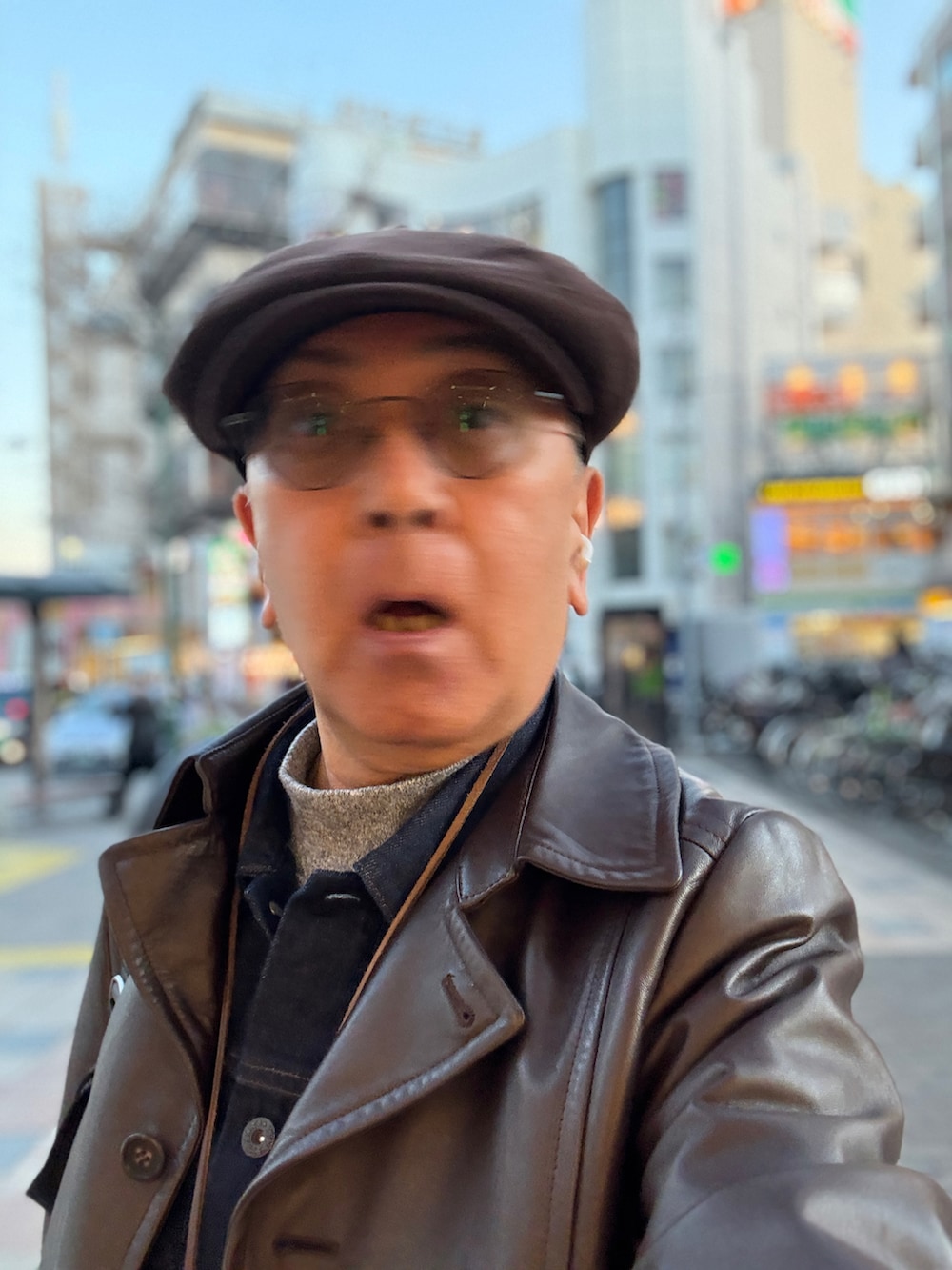 グレー系のTシャツ/カットソー、ブルー系のデニムジャケット、ブラウン系のトレンチコートを着用したメンズの冬コーディネートの3枚目の写真