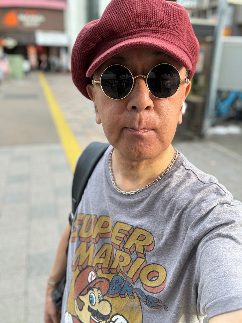 グレー系のデニムパンツ、グレー系のTシャツ/カットソー、レッド系のローファーを着用したメンズの夏コーディネートの2枚目の写真