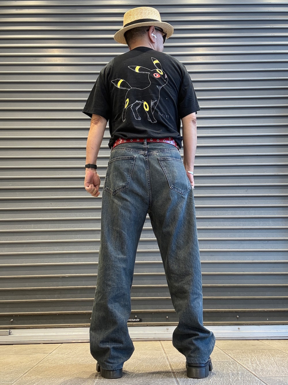ブルー系のデニムパンツ、ブラック系のTシャツ/カットソー、ブラック系のボディバッグ/ウエストポーチを着用したメンズの夏コーディネートの3枚目の写真