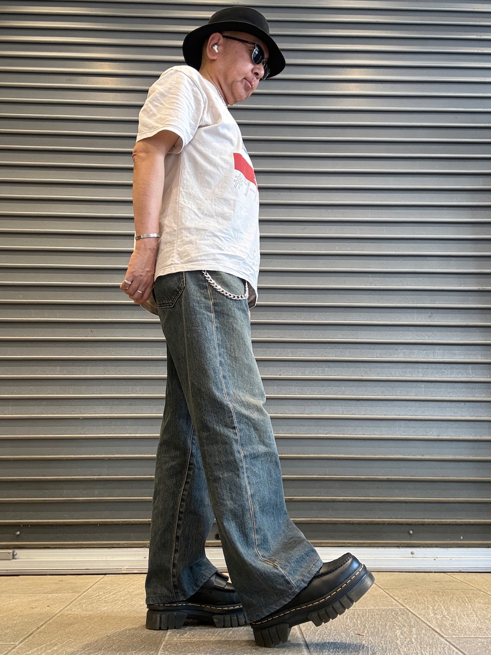 ブルー系のデニムパンツ、ベージュ系のTシャツ/カットソー、ブラック系のローファーを着用したメンズの春コーディネートの3枚目の写真
