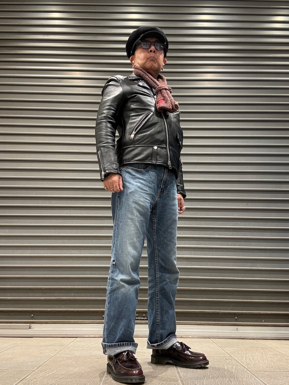 ブラック系のライダースジャケット、ブラック系のニット/セーター、ブルー系のデニムパンツを着用したメンズの冬コーディネートの2枚目の写真