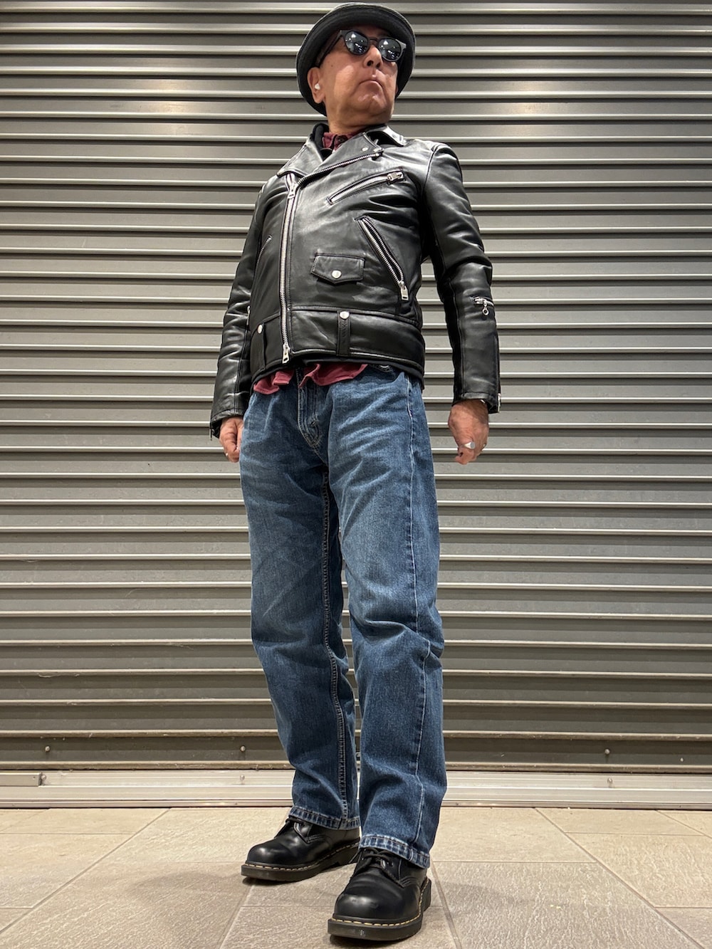 ブラック系のライダースジャケット、ブラック系のスウェット、レッド系のシャツ/ブラウスを着用したメンズの冬コーディネートの2枚目の写真