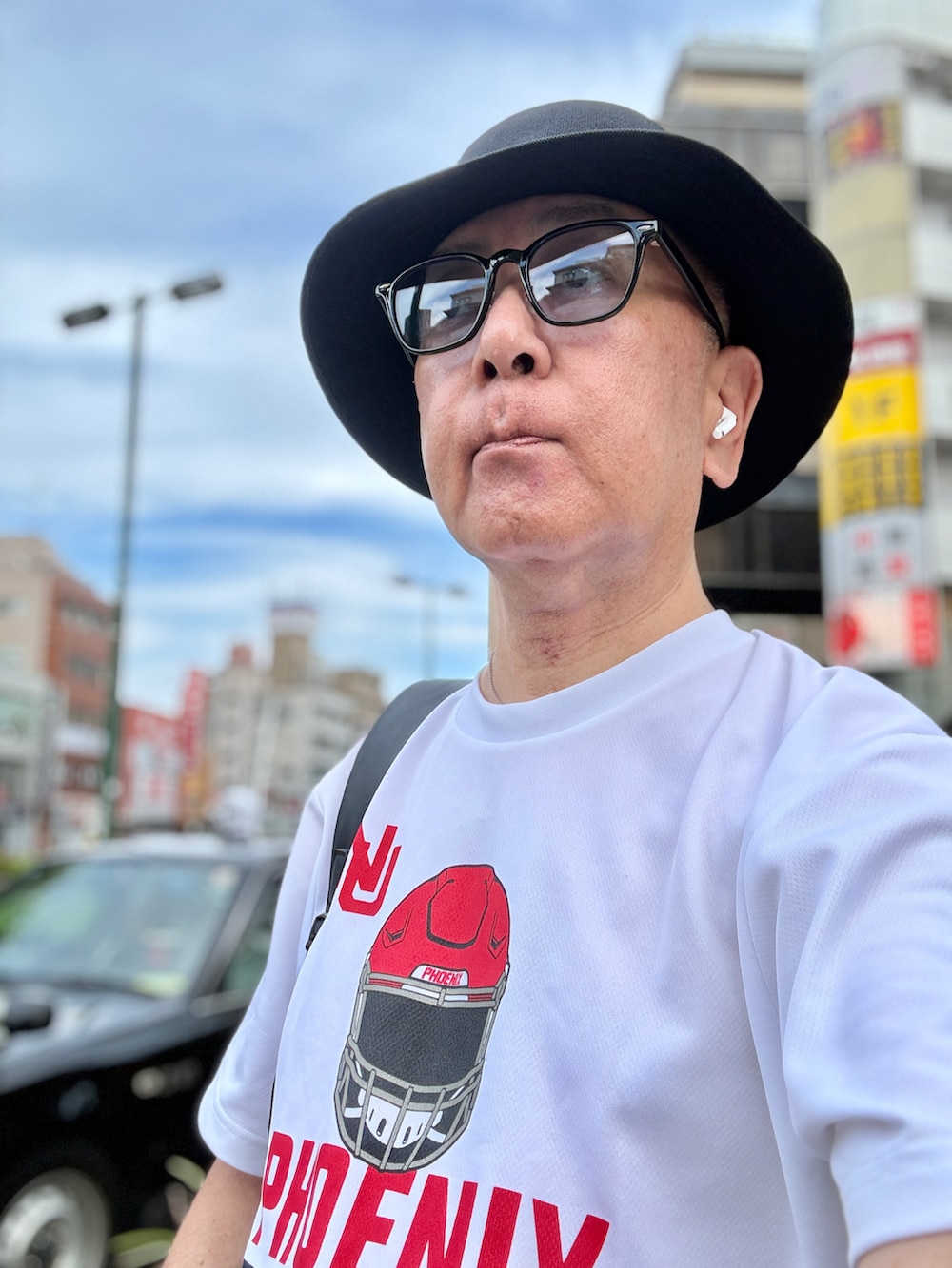 ブルー系のデニムパンツ、ホワイト系のTシャツ/カットソー、ブラック系のバックパック/リュックを着用したメンズの夏コーディネートの2枚目の写真