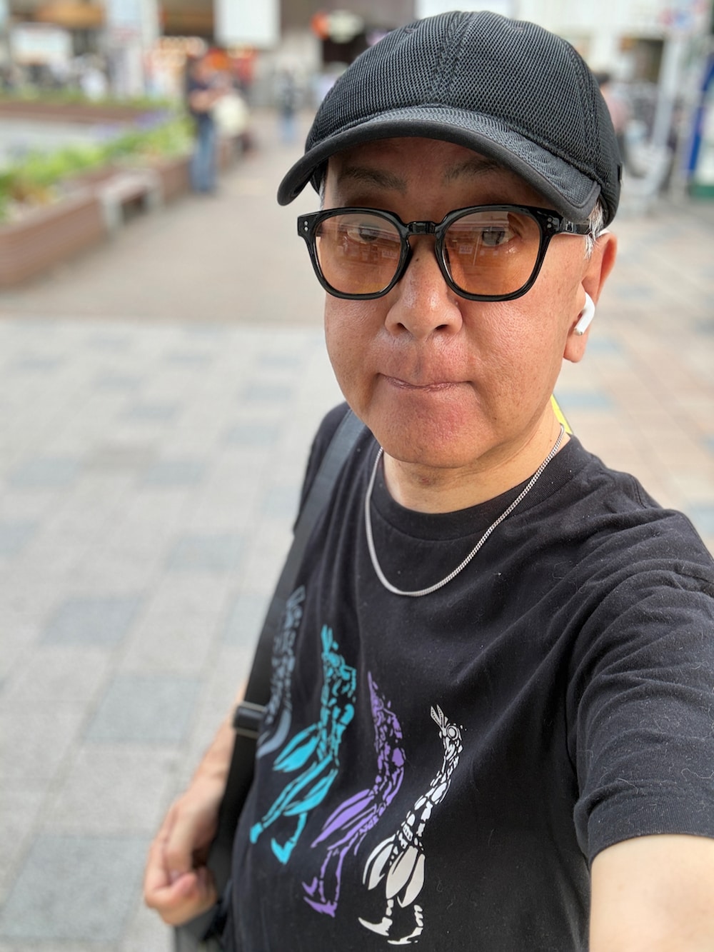 ブラック系のTシャツ/カットソー、ブラック系のショルダーバッグ、ブルー系のスニーカーを着用したメンズの夏コーディネートの4枚目の写真