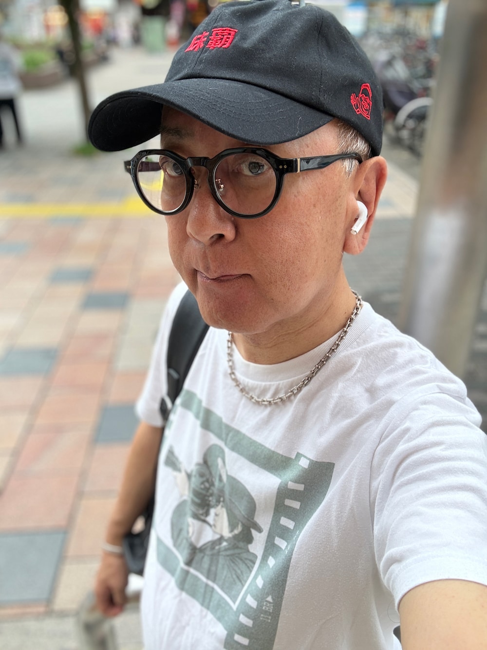 ホワイト系のTシャツ/カットソー、ブラック系のデニムパンツ、ブラック系のバックパック/リュックを着用したメンズの夏コーディネートの3枚目の写真