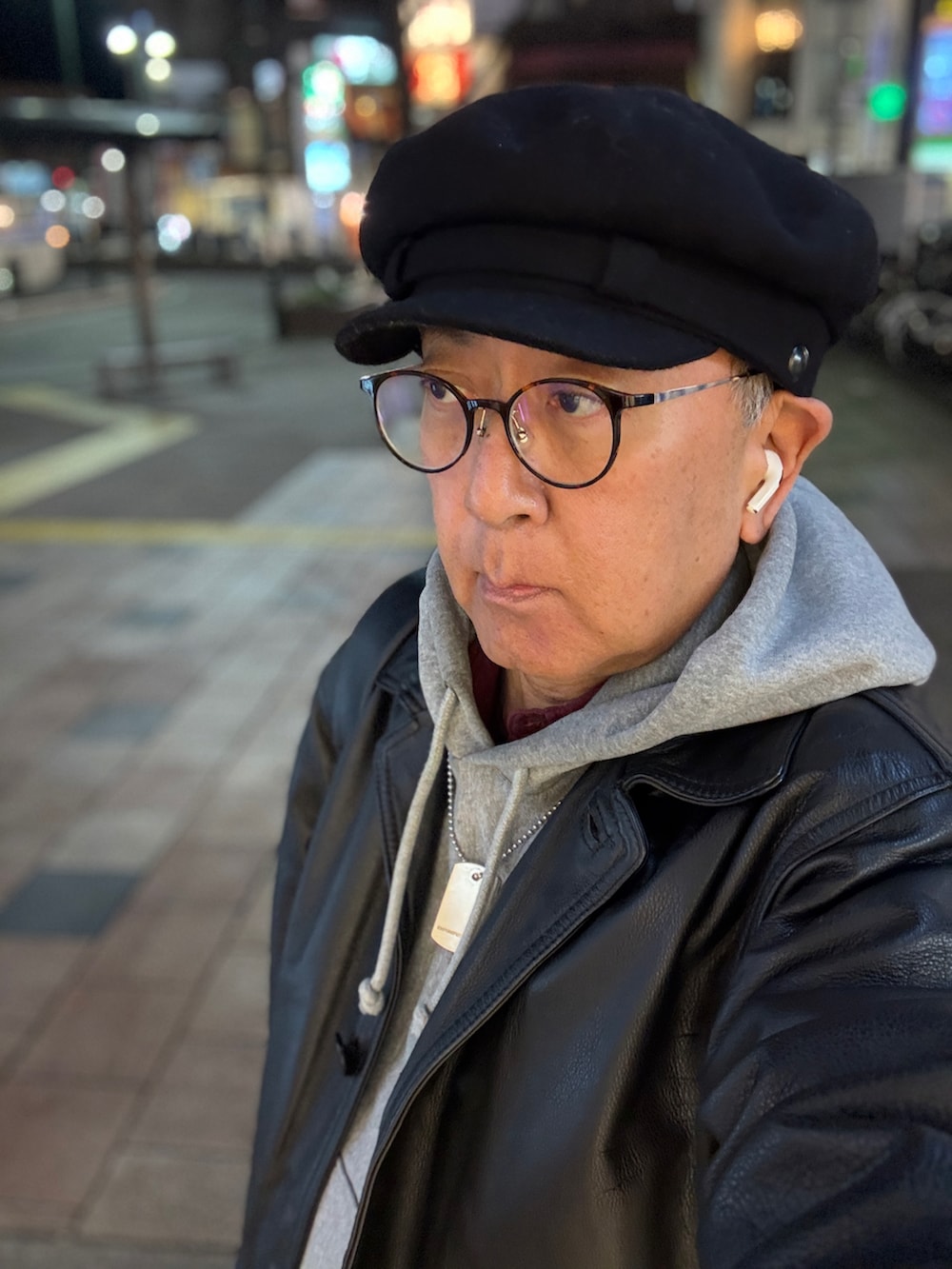 グレー系のパーカー、ブラック系のその他アウター、ブラック系のデニムパンツを着用したメンズの冬コーディネートの2枚目の写真