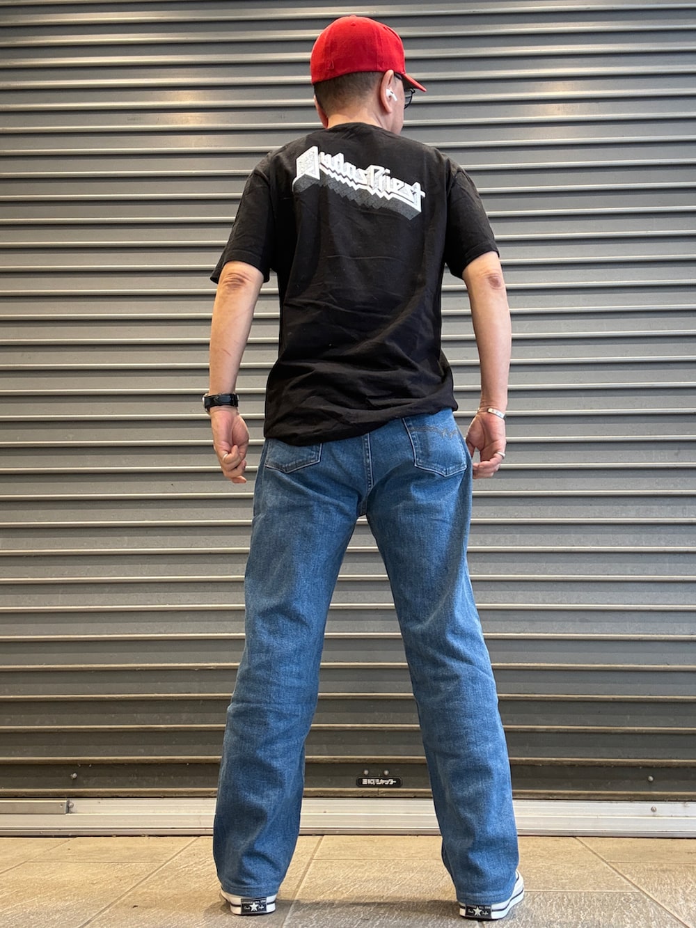 ホワイト系のスニーカー、ブラック系のTシャツ/カットソー、ブルー系のデニムパンツを着用したメンズの夏コーディネートの3枚目の写真