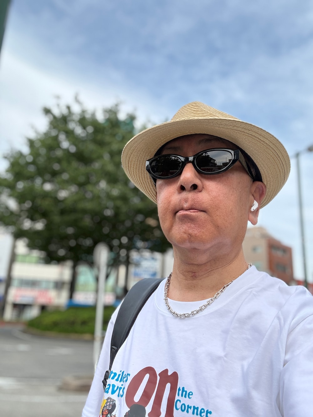ブルー系のデニムパンツ、ホワイト系のTシャツ/カットソー、ホワイト系のスニーカーを着用したメンズの春コーディネートの4枚目の写真