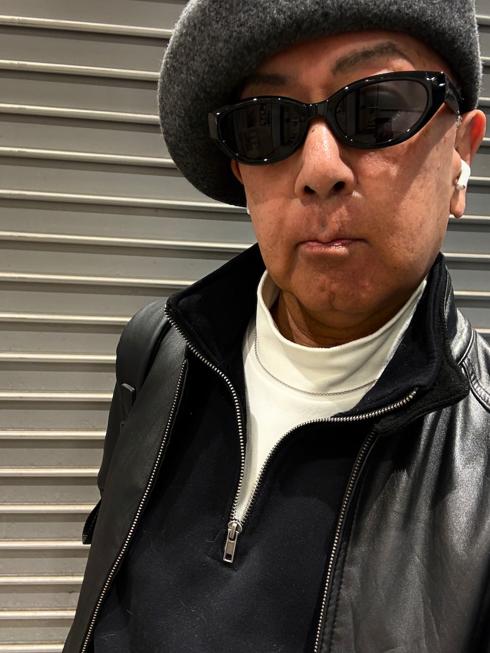 ホワイト系のスニーカー、ブラック系のスウェット、ブラック系のライダースジャケットを着用したメンズの秋コーディネートの2枚目の写真