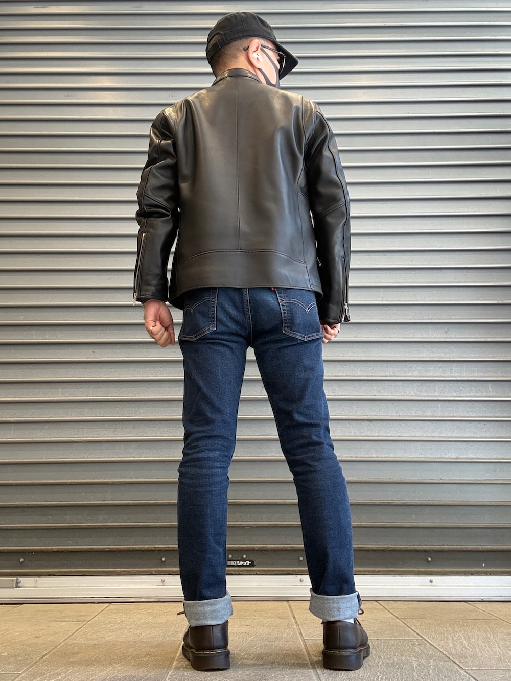 ブルー系のデニムパンツ、ブラック系のライダースジャケット、ホワイト系のシャツ/ブラウスを着用したメンズの春コーディネートの2枚目の写真