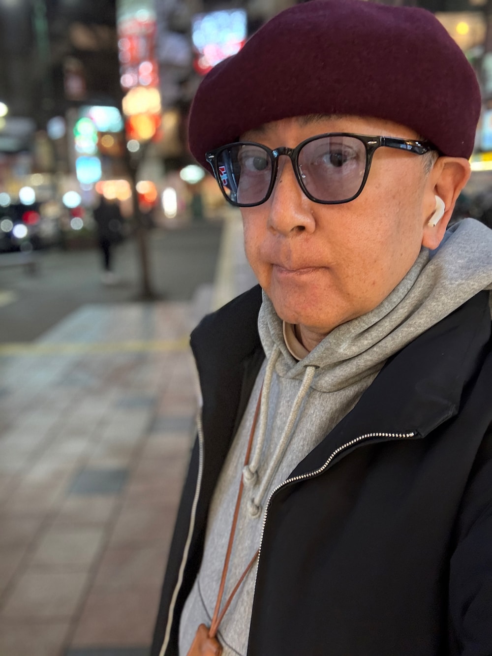 グレー系のパーカー、ブラック系のダウンジャケット/コート、レッド系のブーツを着用したメンズの冬コーディネートの3枚目の写真