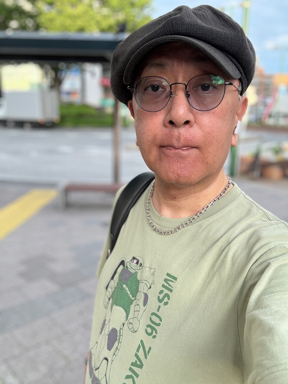 ブルー系のデニムパンツ、グリーン系のTシャツ/カットソー、ブラック系のローファーを着用したメンズの春コーディネートの3枚目の写真