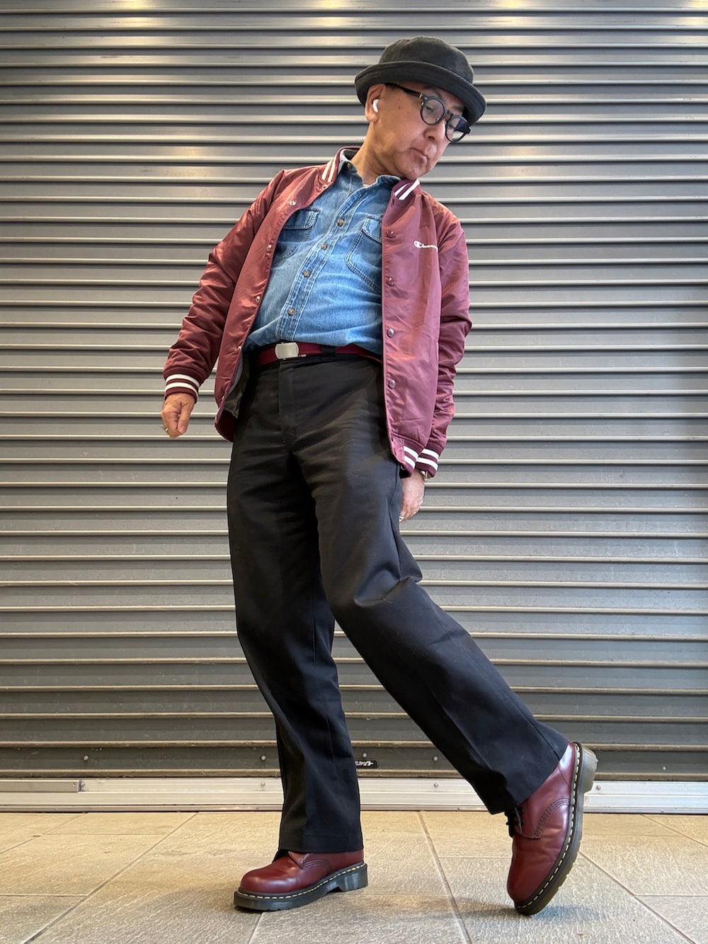 レッド系のナイロンジャケット、ブルー系のシャツ/ブラウス、ブラック系のチノパンツを着用したメンズの冬コーディネートの2枚目の写真