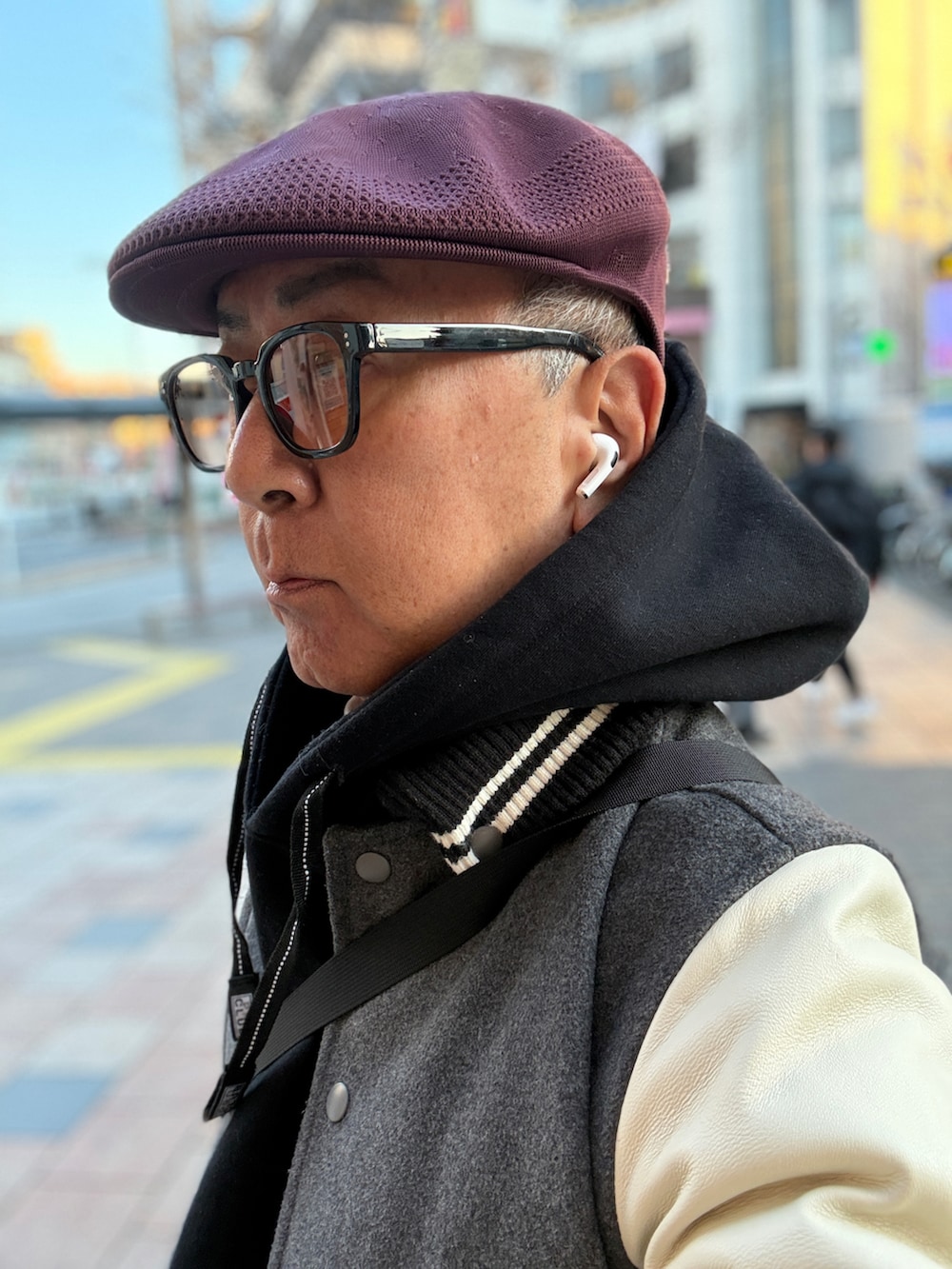 グレー系のスタジャン、ブラック系のパーカー、ブラック系のショルダーバッグを着用したメンズの冬コーディネートの2枚目の写真