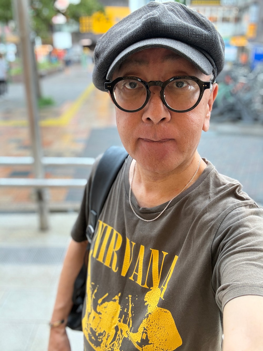 グレー系のTシャツ/カットソー、グレー系のデニムパンツ、ブラック系のバックパック/リュックを着用したメンズの夏コーディネートの2枚目の写真