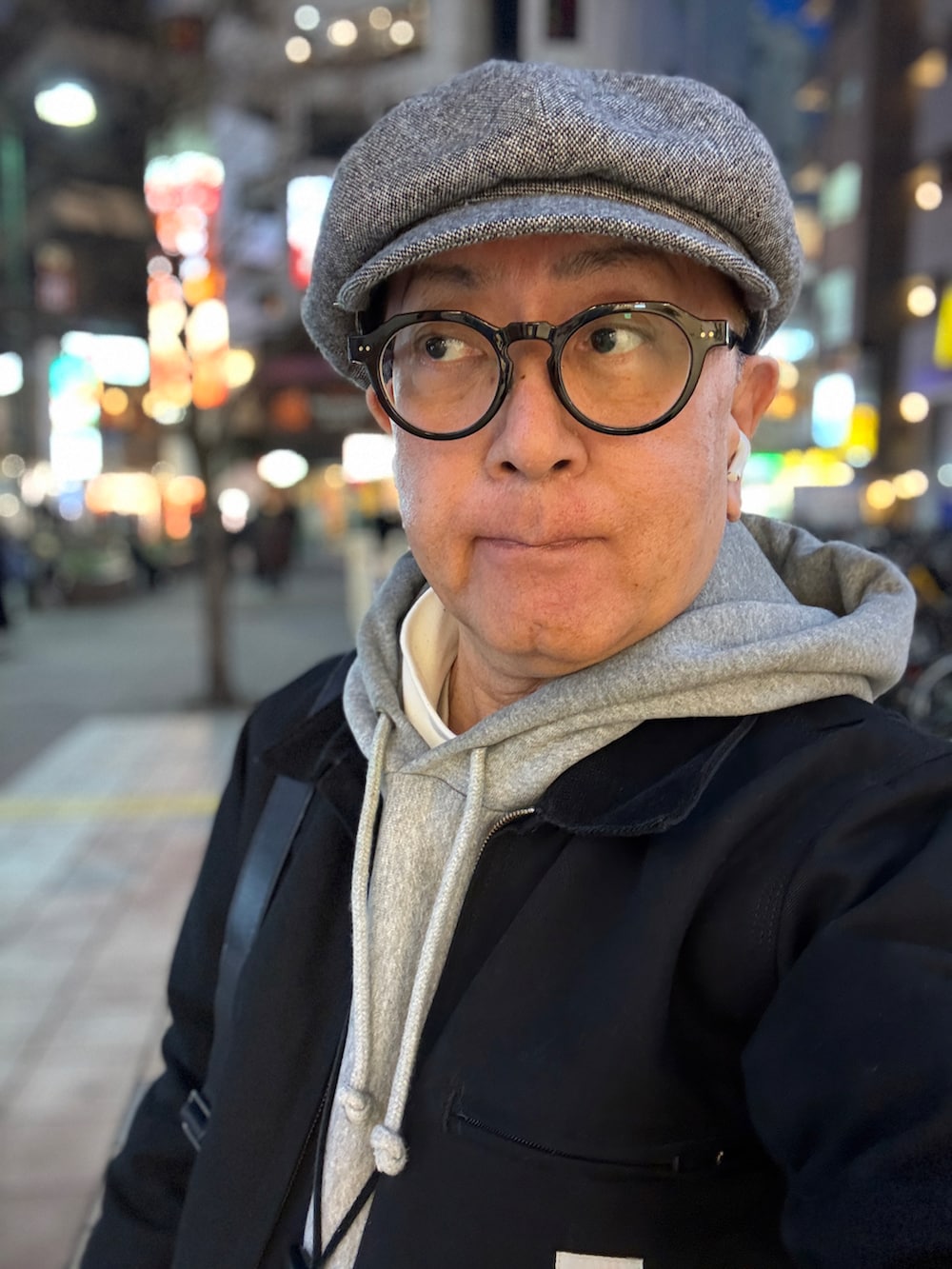 ブラック系のブーツ、ブラック系のその他アウター、レッド系のチノパンツを着用したメンズの春コーディネートの4枚目の写真