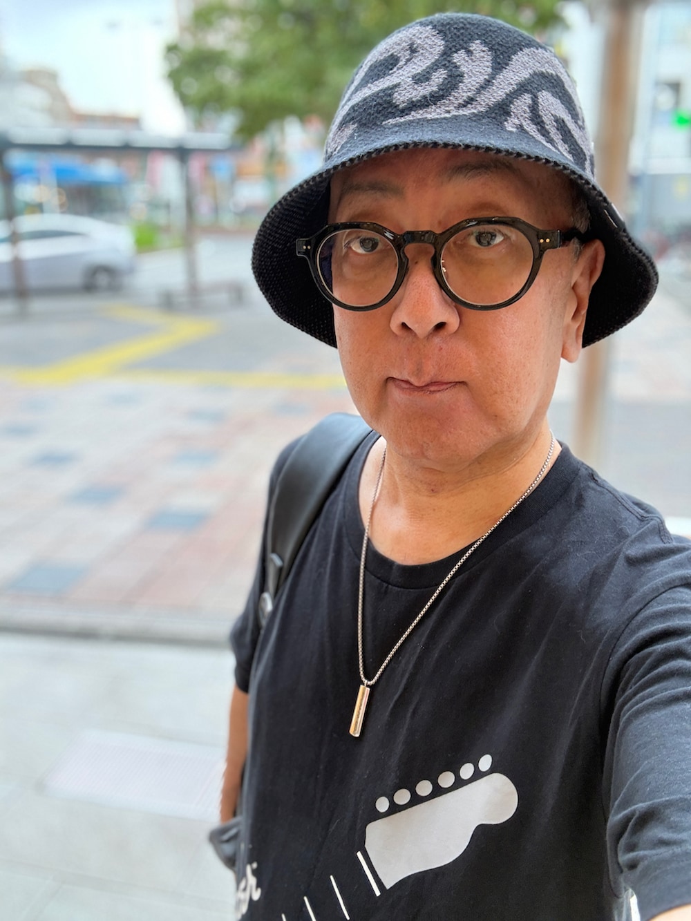 ブルー系のデニムパンツ、ブラック系のTシャツ/カットソー、ブラック系のバックパック/リュックを着用したメンズの夏コーディネートの2枚目の写真
