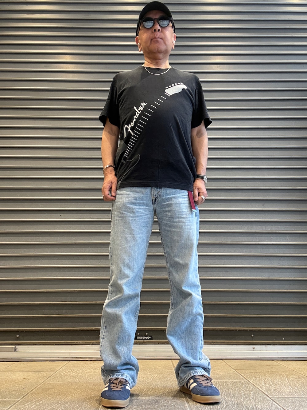 ブルー系のデニムパンツ、ブラック系のTシャツ/カットソー、ブルー系のスニーカーを着用したメンズの夏コーディネートの2枚目の写真