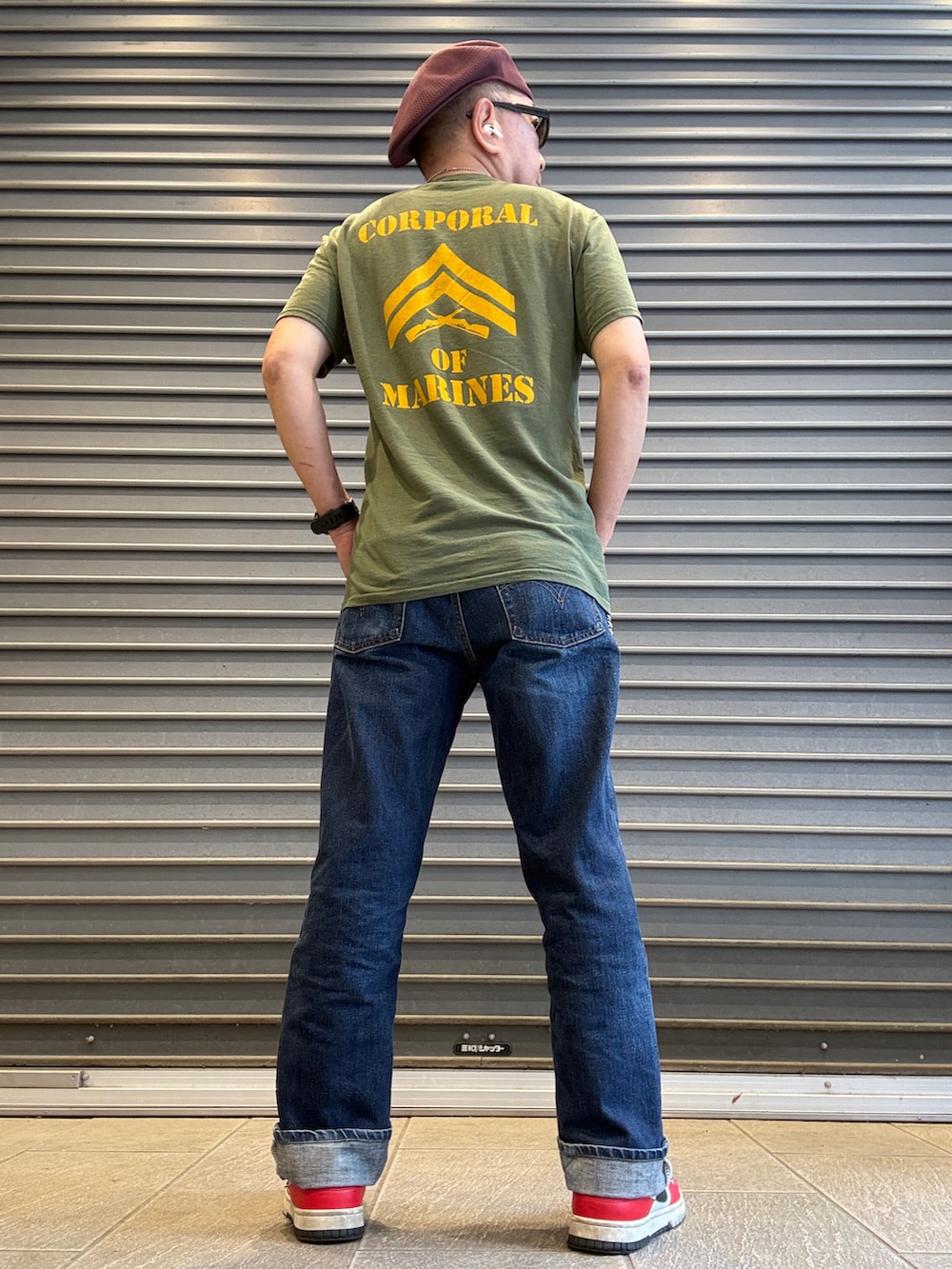 ブルー系のデニムパンツ、グリーン系のTシャツ/カットソー、レッド系のスニーカーを着用したメンズの春コーディネートの2枚目の写真