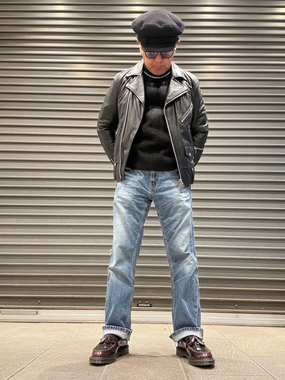 ブラック系のライダースジャケット、ブラック系のニット/セーター、ブルー系のデニムパンツを着用したメンズの冬コーディネートの3枚目の写真