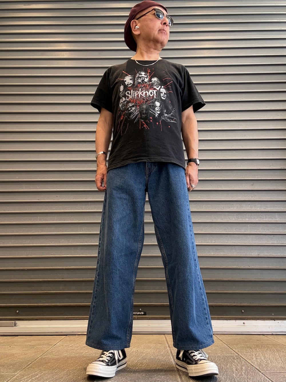 ブラック系のTシャツ/カットソー、ブルー系のデニムパンツ、ブラック系のスニーカーを着用したメンズの秋コーディネートの2枚目の写真