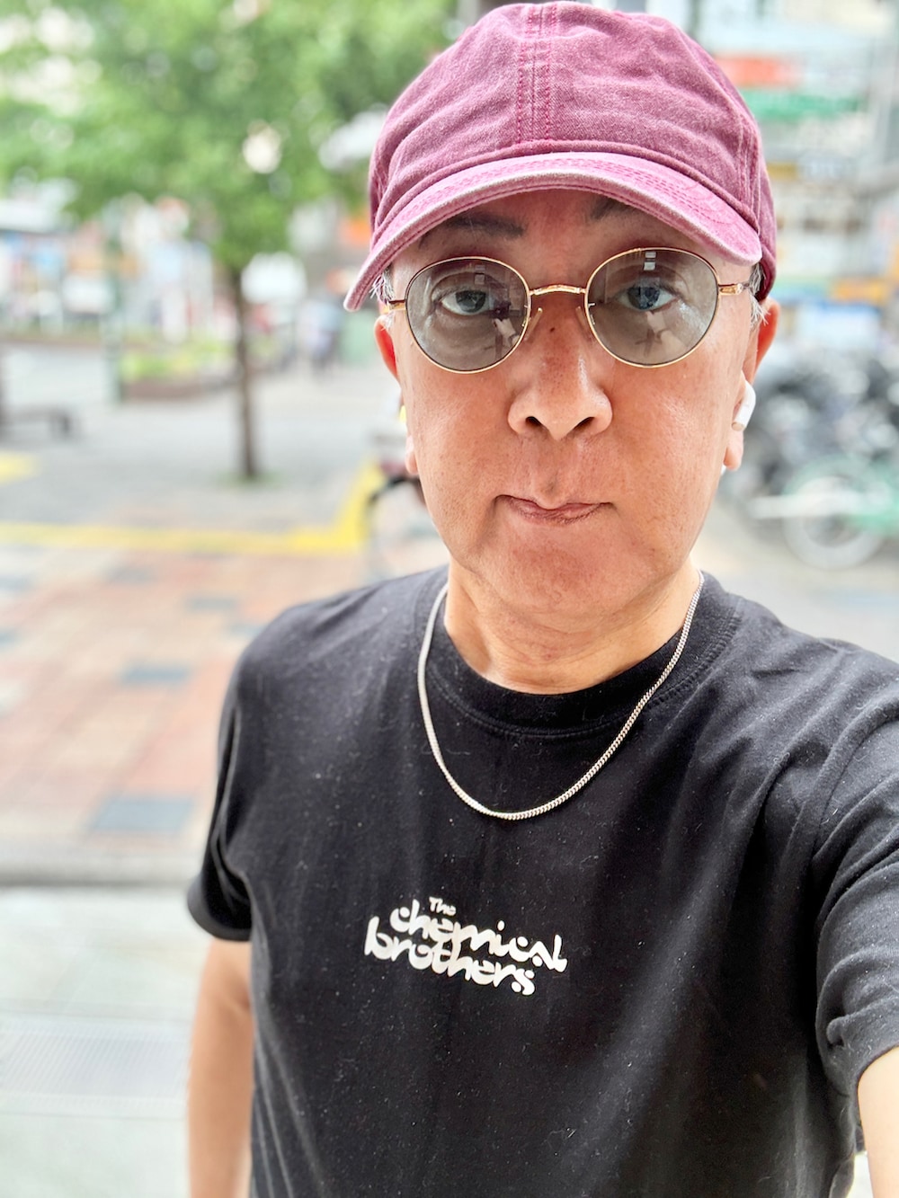 ブルー系のデニムパンツ、ブラック系のTシャツ/カットソー、レッド系のスニーカーを着用したメンズの春コーディネートの3枚目の写真