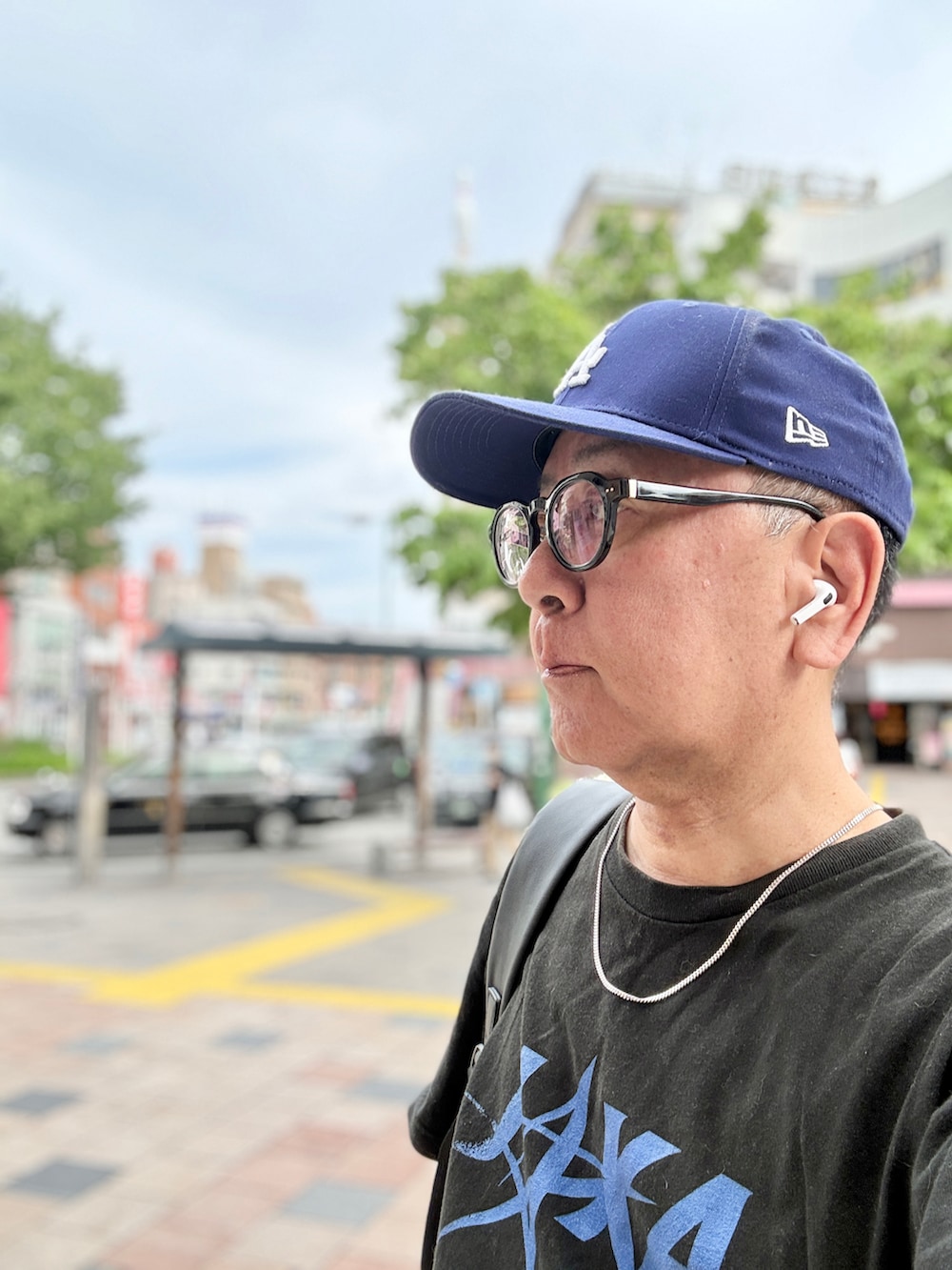 ブラック系のデニムパンツ、ブラック系のTシャツ/カットソー、ホワイト系のスニーカーを着用したメンズの春コーディネートの2枚目の写真