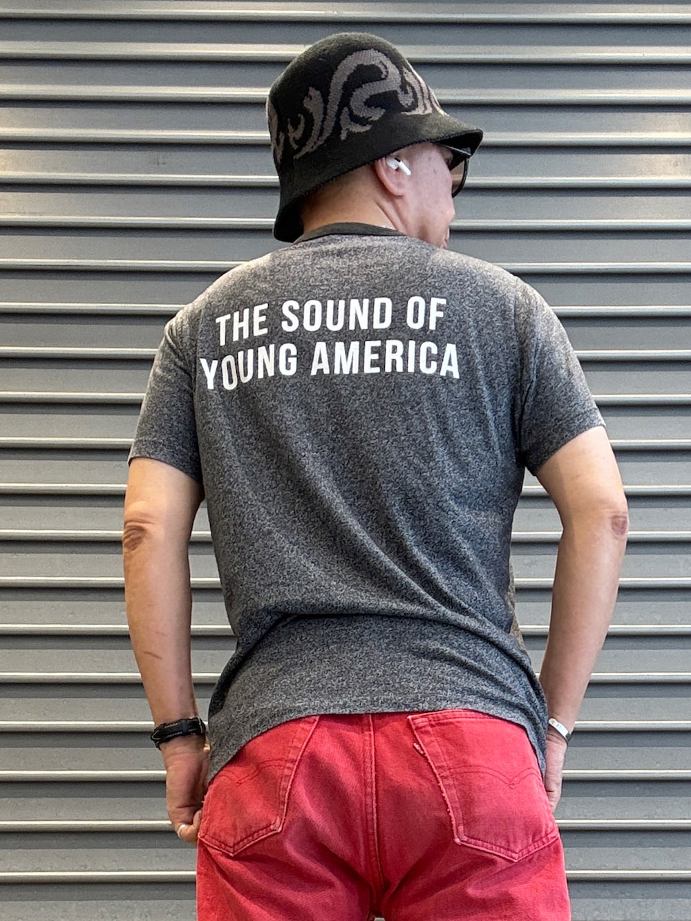 ホワイト系のスニーカー、グレー系のTシャツ/カットソー、レッド系のデニムパンツを着用したメンズの春コーディネートの3枚目の写真