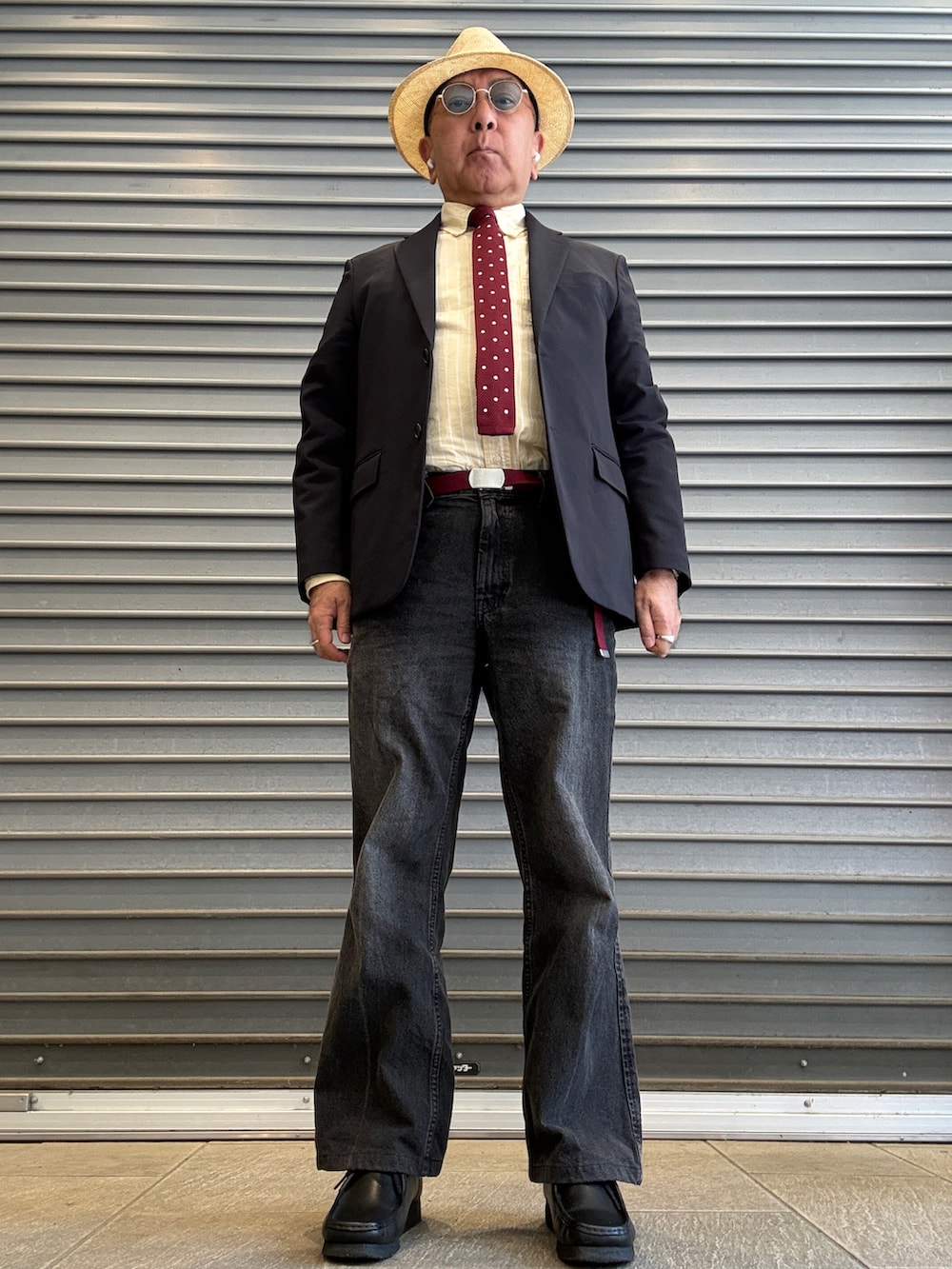 ブラック系のモカシン/デッキシューズ、イエロー系のシャツ/ブラウス、ブルー系のテーラードジャケットを着用したメンズの春コーディネートの2枚目の写真