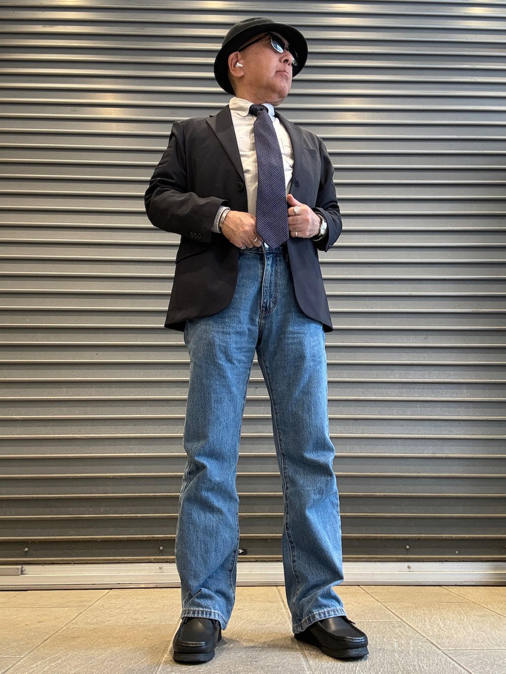 ブラック系のモカシン/デッキシューズ、ブルー系のデニムパンツ、グレー系のシャツ/ブラウスを着用したメンズの春コーディネートの2枚目の写真