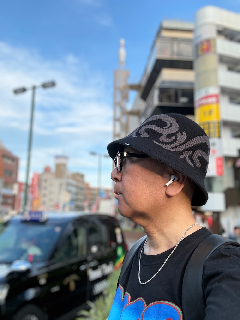 ブラック系のTシャツ/カットソー、ブルー系のデニムパンツ、ブラック系のバックパック/リュックを着用したメンズの夏コーディネートの2枚目の写真