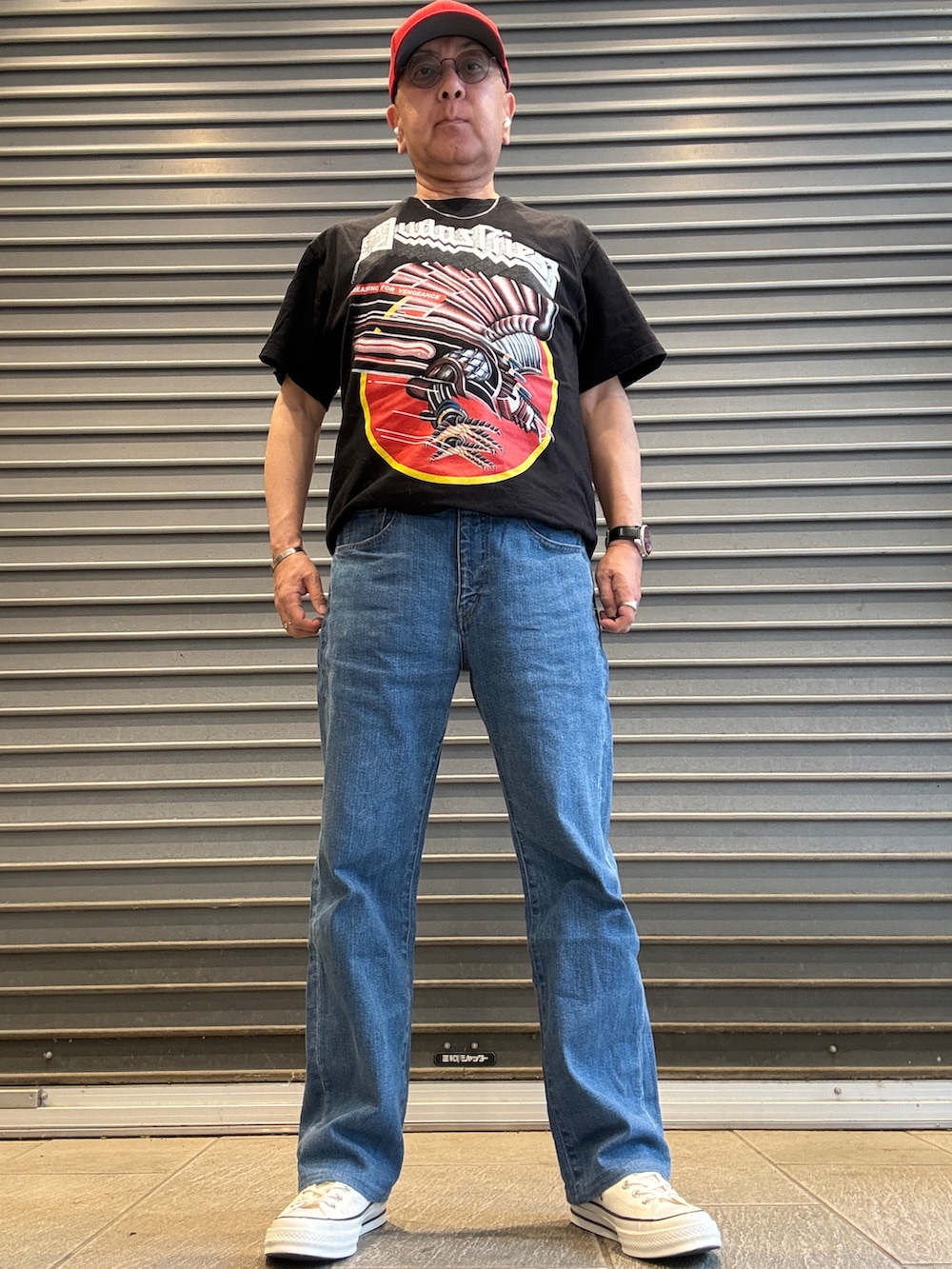 ホワイト系のスニーカー、ブラック系のTシャツ/カットソー、ブルー系のデニムパンツを着用したメンズの夏コーディネートの2枚目の写真