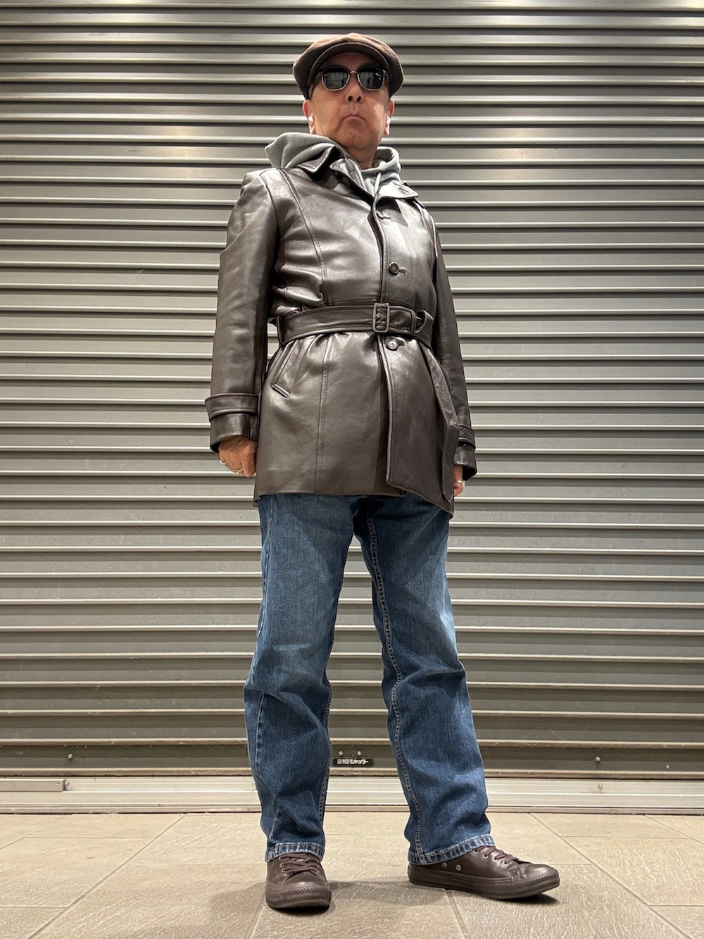 ブラウン系のトレンチコート、グレー系のパーカー、ブルー系のデニムパンツを着用したメンズの冬コーディネートの2枚目の写真