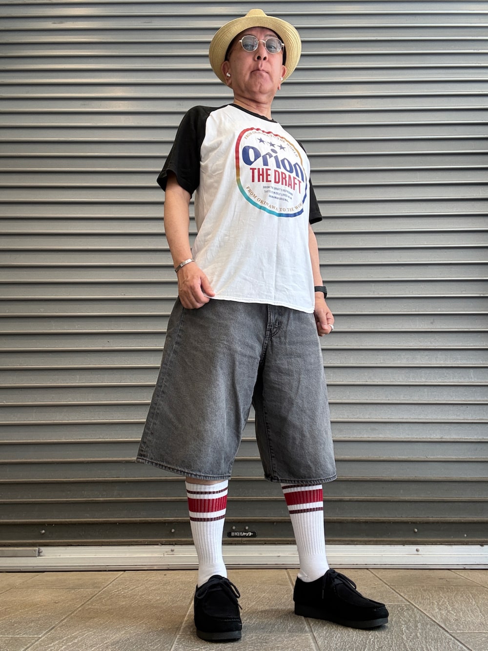 グレー系のデニムパンツ、ホワイト系のTシャツ/カットソー、ブラック系のモカシン/デッキシューズを着用したメンズの夏コーディネートの2枚目の写真