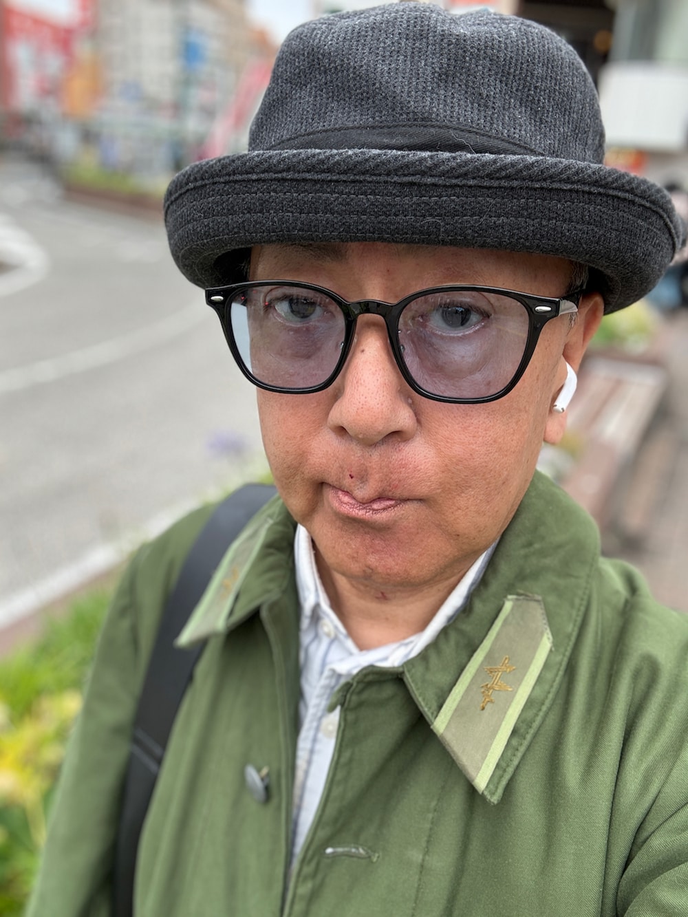 ホワイト系のシャツ/ブラウス、グリーン系のミリタリージャケット、ブルー系のデニムパンツを着用したメンズの春コーディネートの2枚目の写真