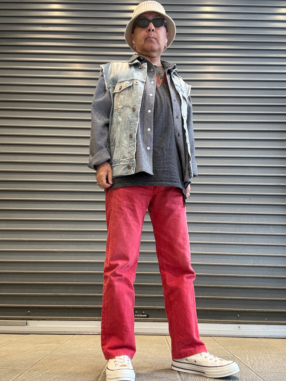 ホワイト系のスニーカー、ブルー系のベスト、ブラック系のシャツ/ブラウスを着用したメンズの春コーディネートの2枚目の写真